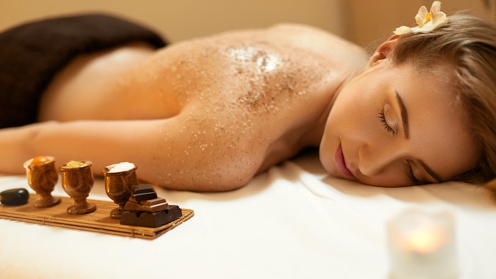 woman getting body exfoliation treatment