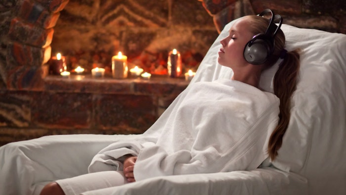 Woman relaxing in salt cave with headphones on
