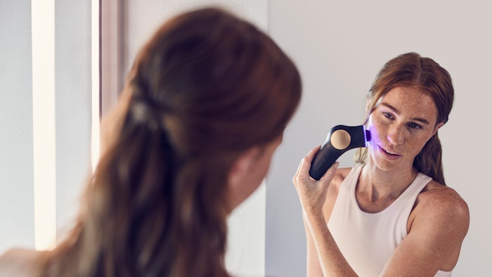 Woman using therabody theraface PRO on her face
