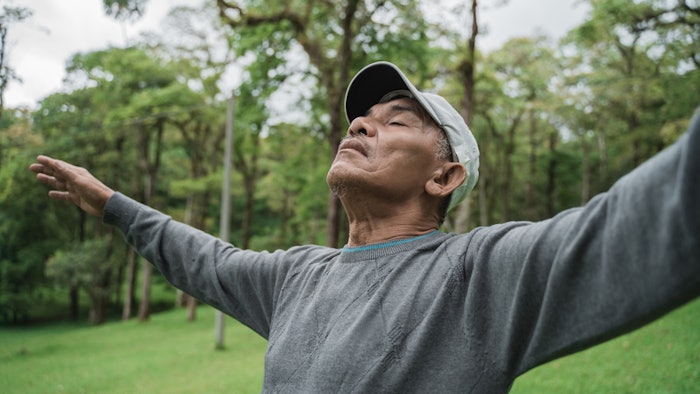 respiratory wellness, senior man taking a deep breath in nature