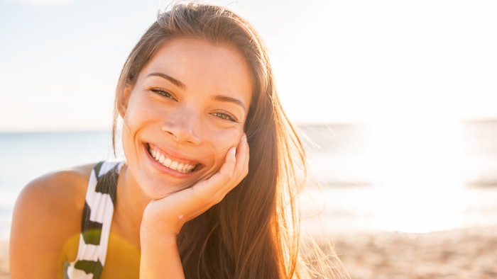 woman with beautiful hair smiling in the summer sun