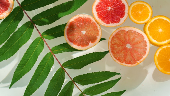 Bathtub with citrus slices and leaves in water