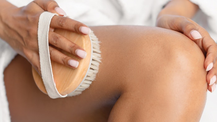 Woman body brushing her leg