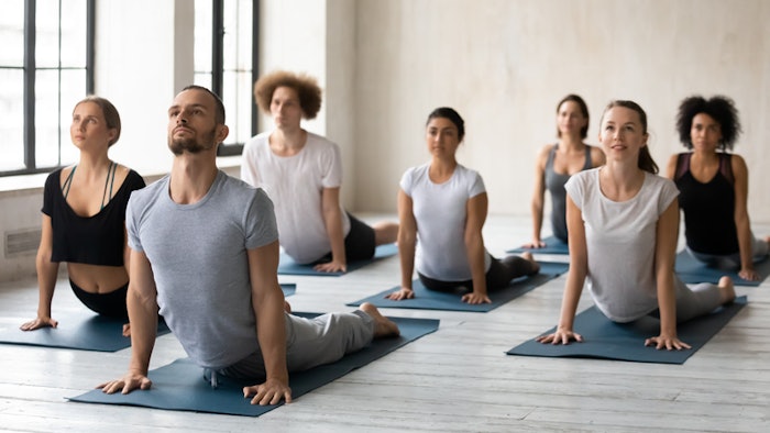 group yoga class doing cobra pose trauma informed yoga