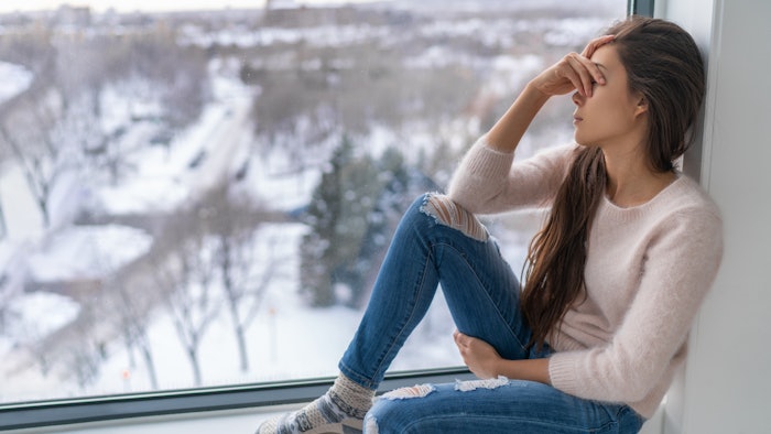 woman suffering from depression, seasonal affective disorder, during winter