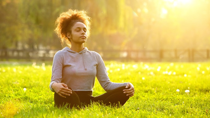 black woman performing yoga in nature