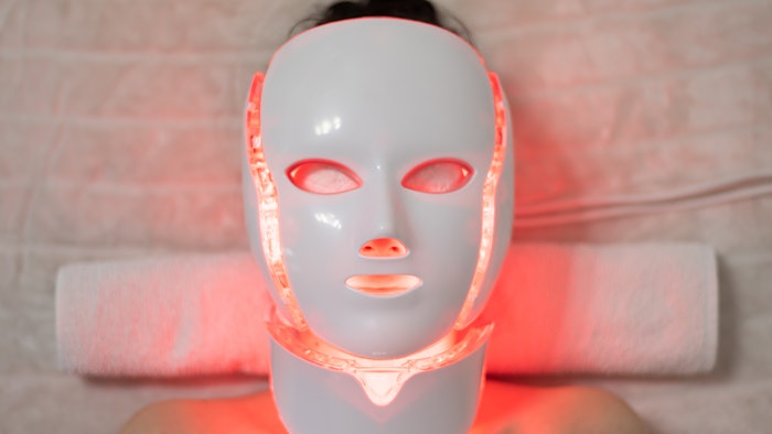 Woman wearing LED mask in spa