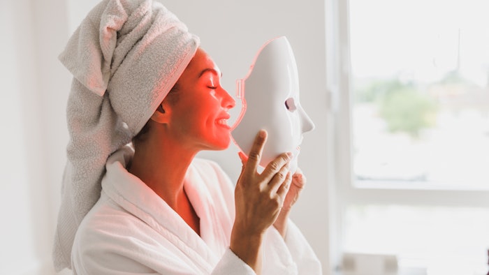 Woman enjoying A red Led Light Facial Mask Treatment At home