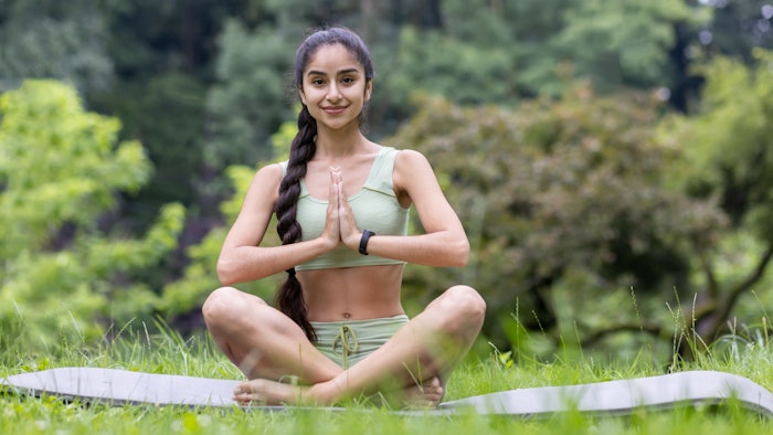 Portrait of a beautiful young woman sitting in a beautiful yoga